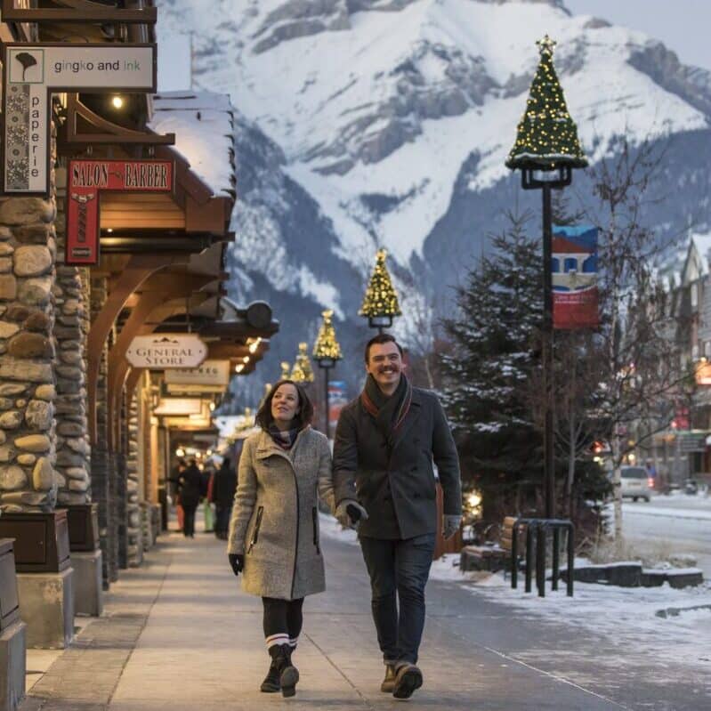 https://www.discovercanadatours.com/wp-content/uploads/2022/05/Christmas_Couple_BanffAve_NoelHendrickson_005-large-1-e1657653226362.jpg